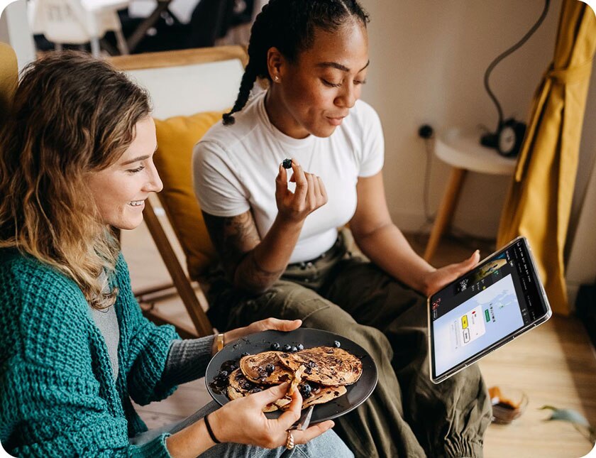 Two women connect to a VPN on their tablet to access content across borders.