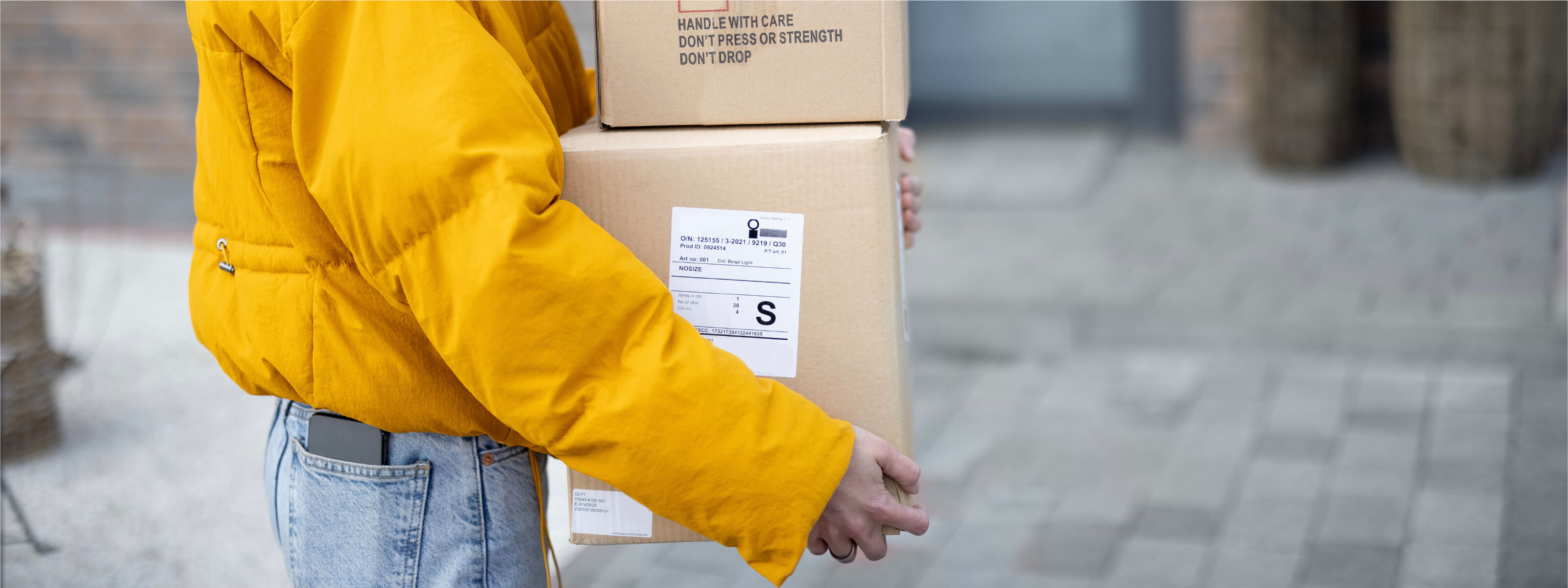 A woman carries boxes into a secure location, which could be targeted in a tailgating attack