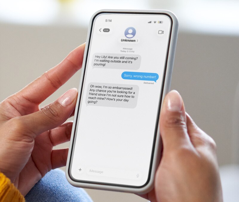 An image of someone reading a wrong number text scam.